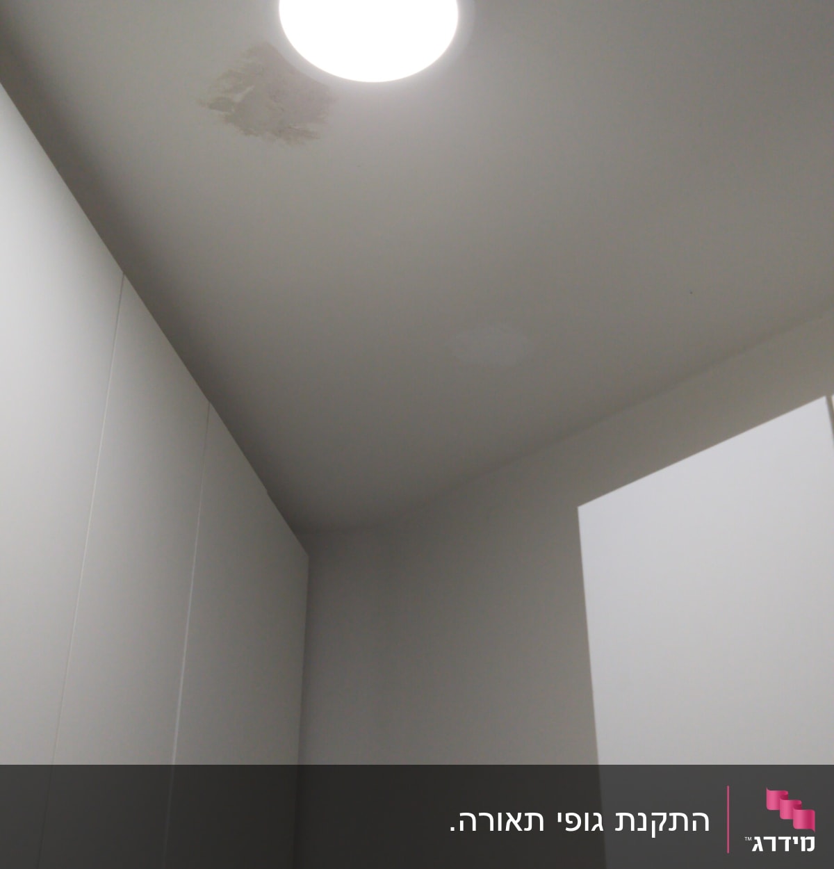 תאורה עגולה בתקרה עם כתם רטיבות